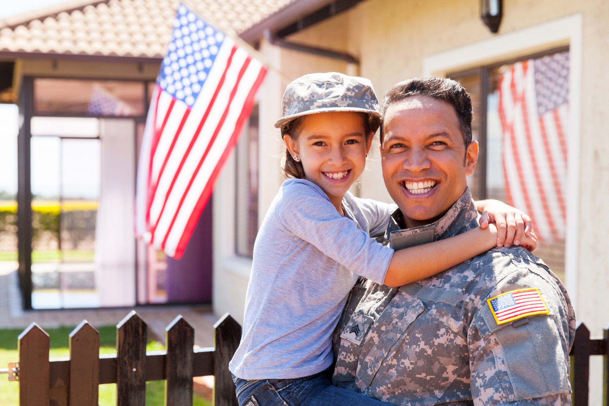 shutterstock_350910998 US Army soldier and little daughter outside their home.